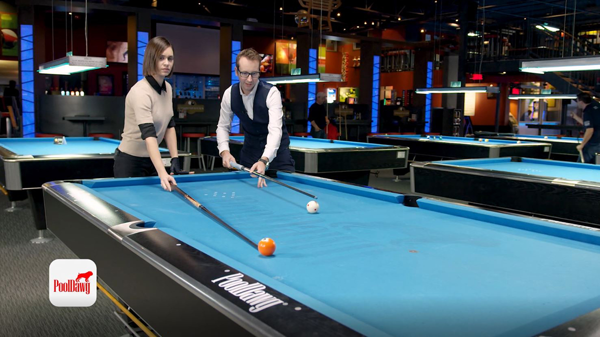Florian and Valerie use their cues to visualize the line through the five into the pocket, and the parallel line through the cue ball